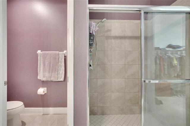 bathroom featuring an enclosed shower, toilet, and tile patterned floors