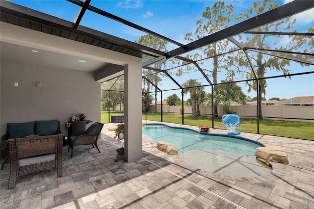 view of swimming pool featuring a yard, a patio, and a lanai