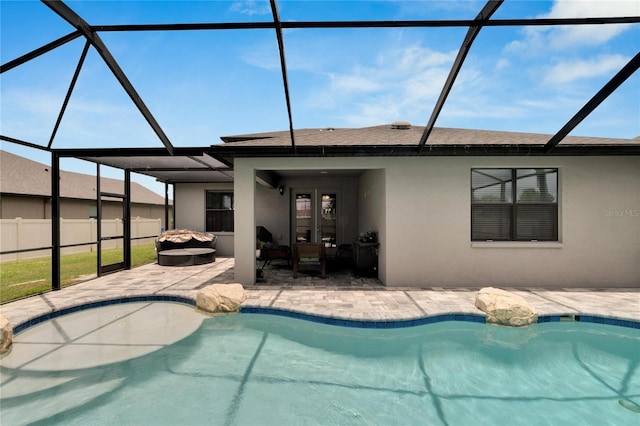 view of swimming pool featuring glass enclosure, a patio area, and french doors