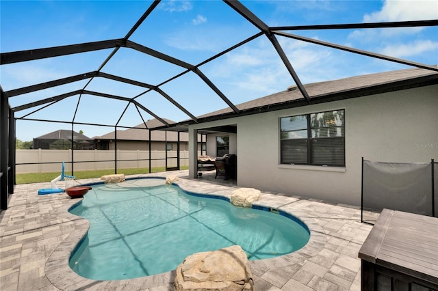 view of pool with glass enclosure and a patio area