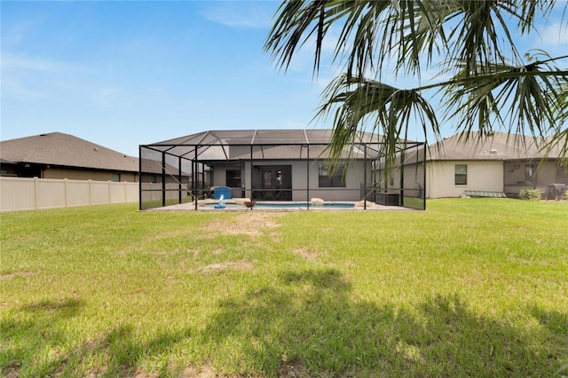 back of property with a lawn, glass enclosure, and a fenced in pool