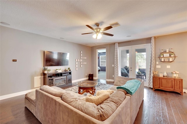 living room featuring french doors, dark hardwood / wood-style flooring, a textured ceiling, and ceiling fan