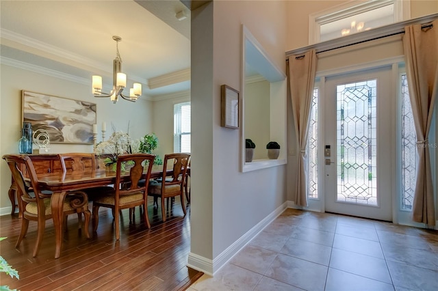 entrance foyer with a notable chandelier, wood-type flooring, and ornamental molding