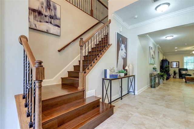 staircase with ceiling fan and ornamental molding