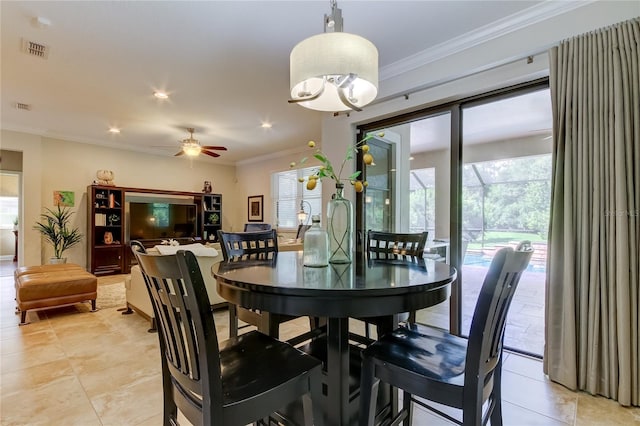 tiled dining space featuring ceiling fan with notable chandelier, crown molding, and a healthy amount of sunlight