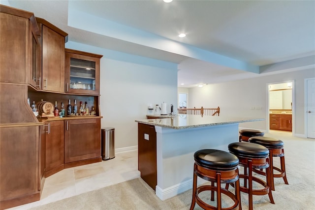 interior space featuring light carpet, a tray ceiling, light stone counters, and sink