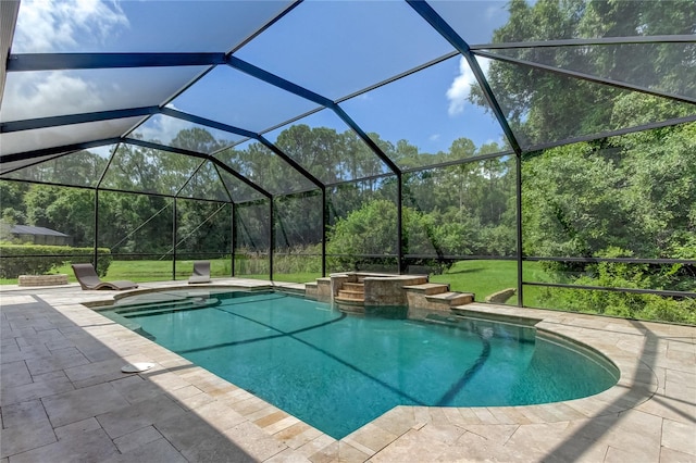 view of swimming pool featuring glass enclosure, an in ground hot tub, and a patio