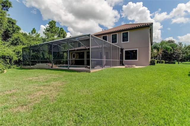 back of house featuring a yard, a patio, and a lanai