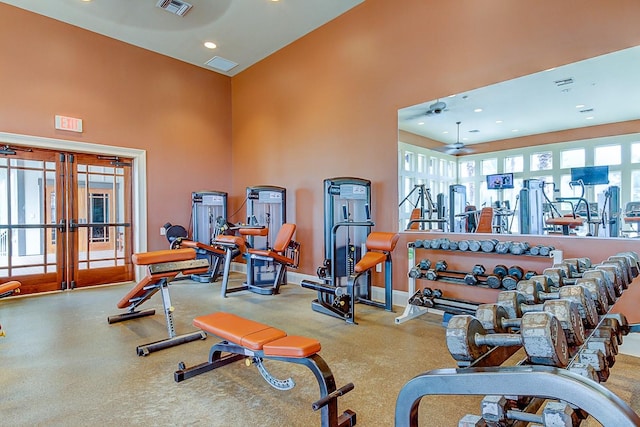 exercise room featuring a high ceiling, french doors, and ceiling fan