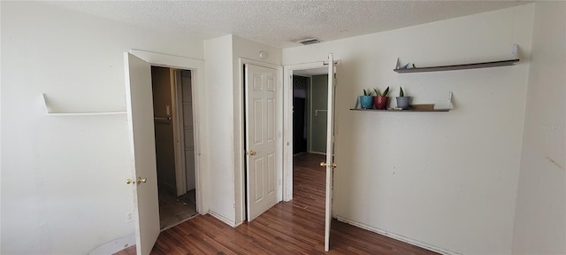 unfurnished bedroom featuring dark hardwood / wood-style floors and a textured ceiling