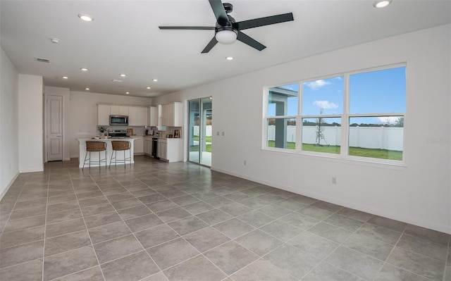 unfurnished living room featuring ceiling fan and light tile patterned flooring