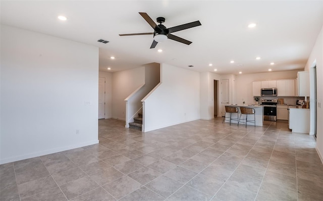 unfurnished living room featuring ceiling fan and light tile patterned floors