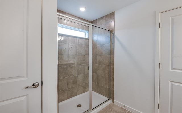 bathroom with a shower with shower door and tile patterned floors