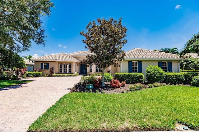 mediterranean / spanish-style home with a front lawn