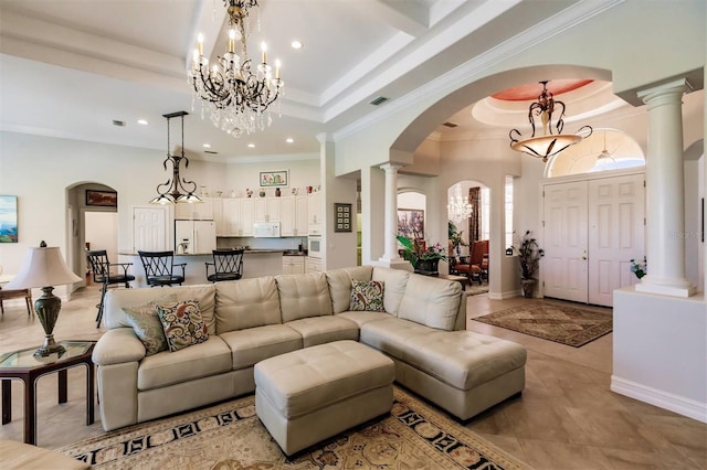 living room with light tile patterned floors, crown molding, a chandelier, and a tray ceiling