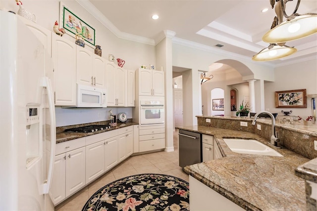 kitchen with appliances with stainless steel finishes, sink, dark stone countertops, and decorative light fixtures