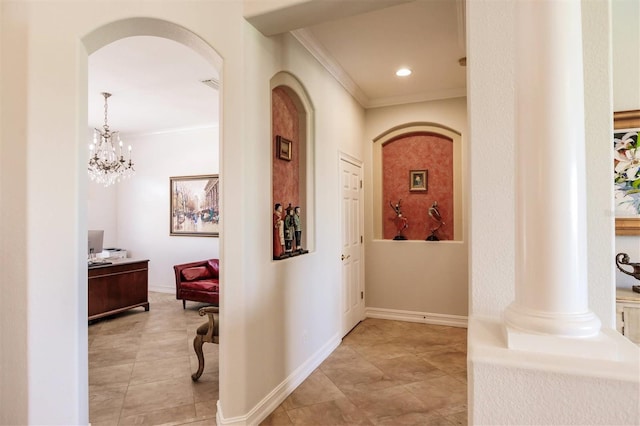 corridor with a notable chandelier, decorative columns, light tile patterned floors, and crown molding