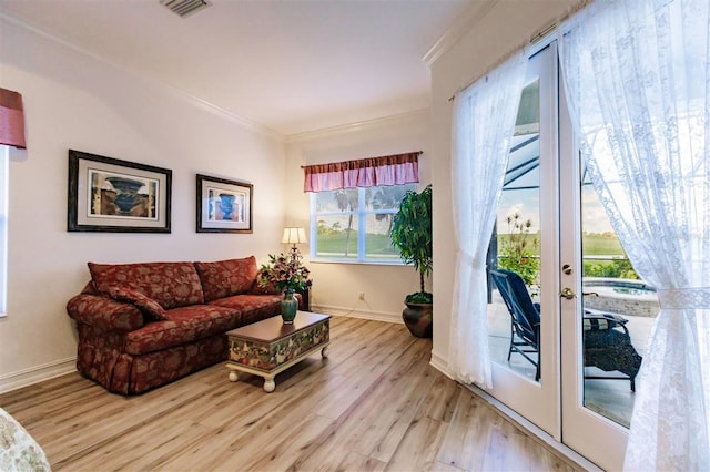 living room with crown molding, french doors, and light hardwood / wood-style floors