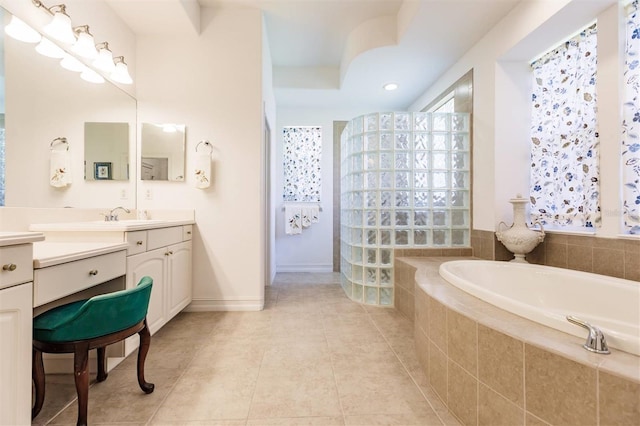 bathroom featuring tiled bath, tile patterned flooring, and vanity