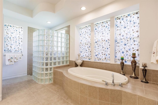 bathroom with tile patterned floors and tiled bath