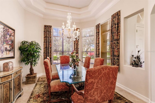 tiled dining room featuring a notable chandelier, ornamental molding, and a raised ceiling