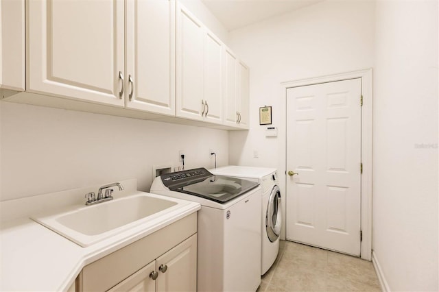 clothes washing area with cabinets, light tile patterned flooring, sink, and separate washer and dryer