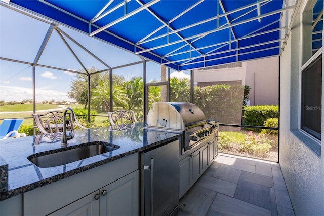 view of patio / terrace featuring exterior kitchen, a lanai, area for grilling, and sink