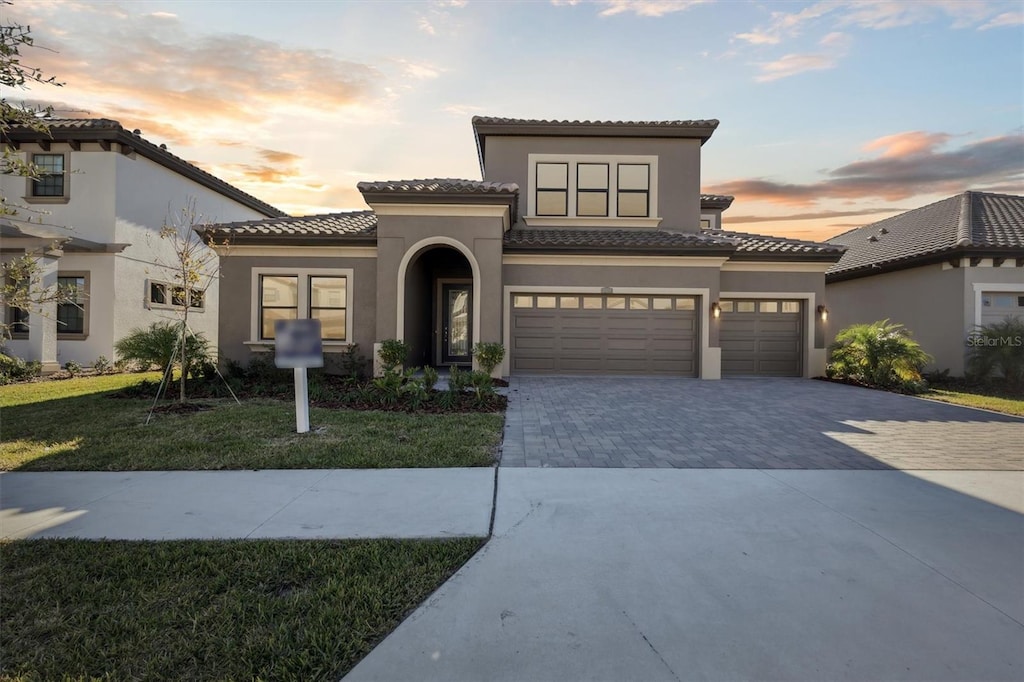 mediterranean / spanish house with a yard and a garage