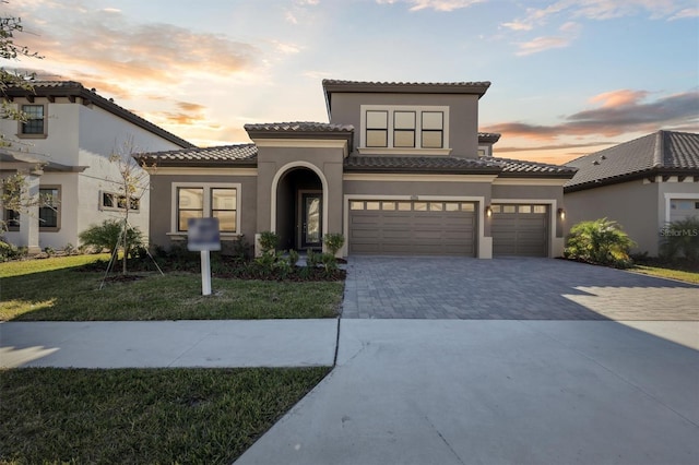 mediterranean / spanish house with a yard and a garage