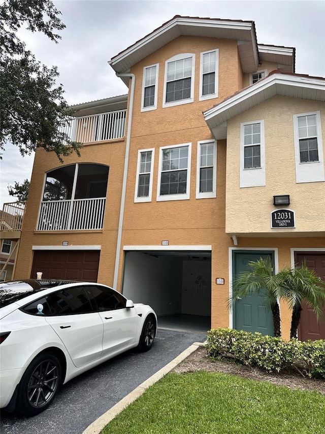 townhome / multi-family property with a balcony and a garage