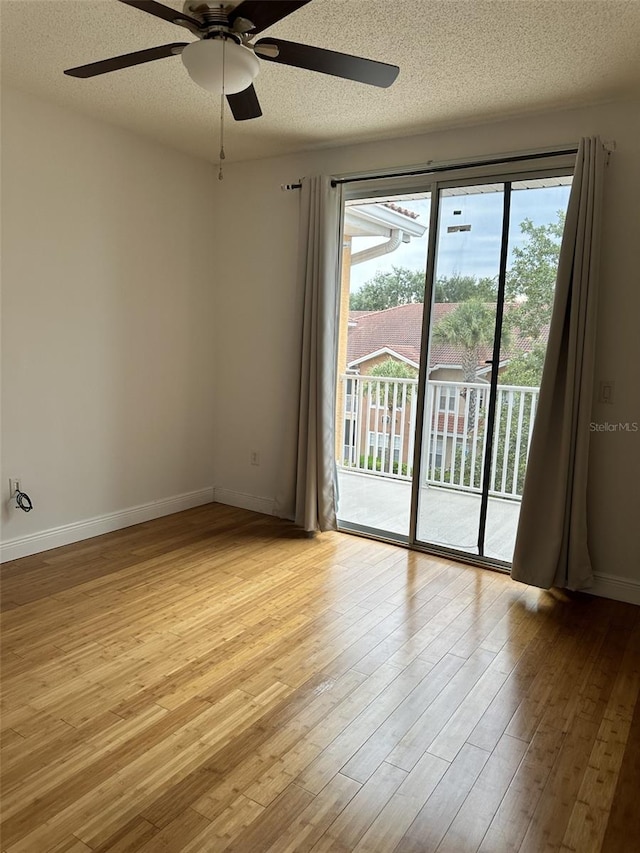 spare room featuring light wood-type flooring, ceiling fan, and a textured ceiling