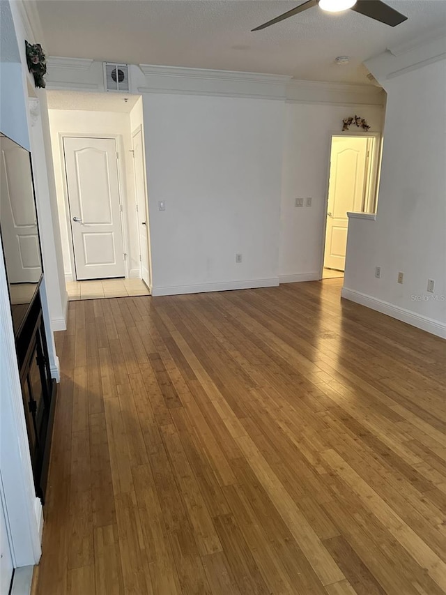 empty room with wood-type flooring, ornamental molding, and ceiling fan