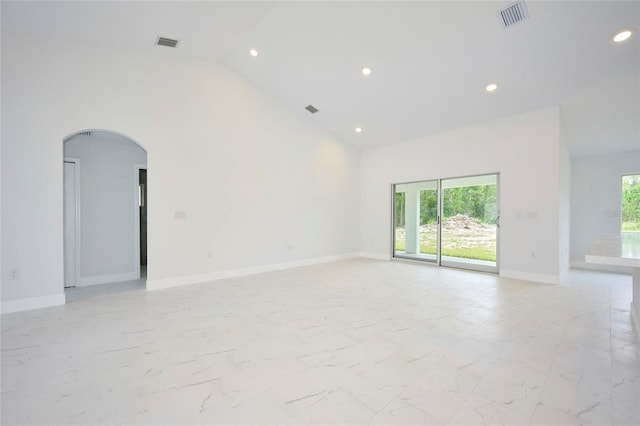 unfurnished room with high vaulted ceiling