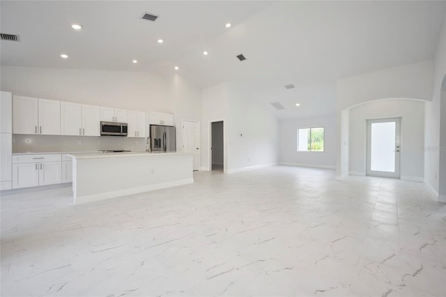 unfurnished living room featuring high vaulted ceiling