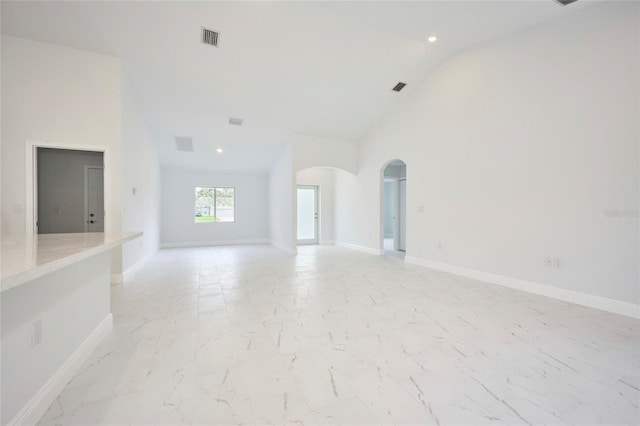 unfurnished living room with high vaulted ceiling