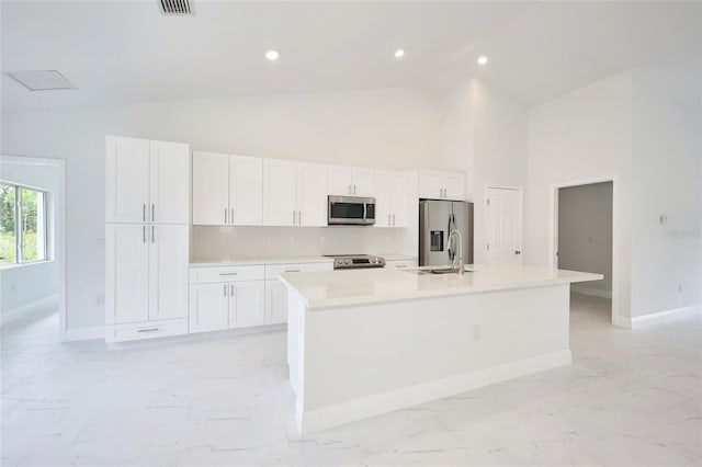 kitchen featuring sink, white cabinetry, high vaulted ceiling, stainless steel appliances, and a kitchen island with sink