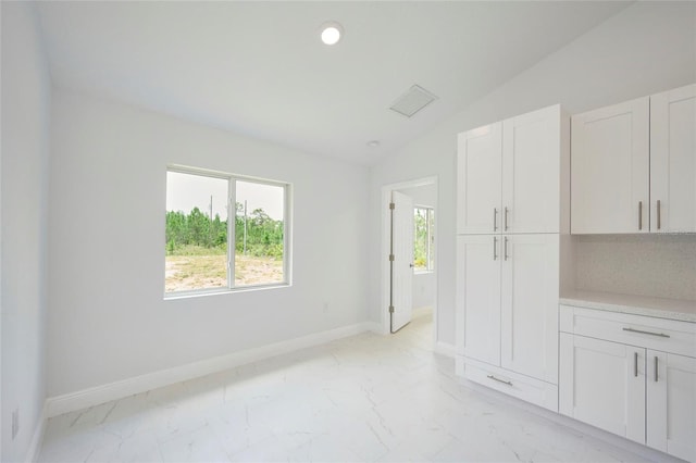 unfurnished room with lofted ceiling