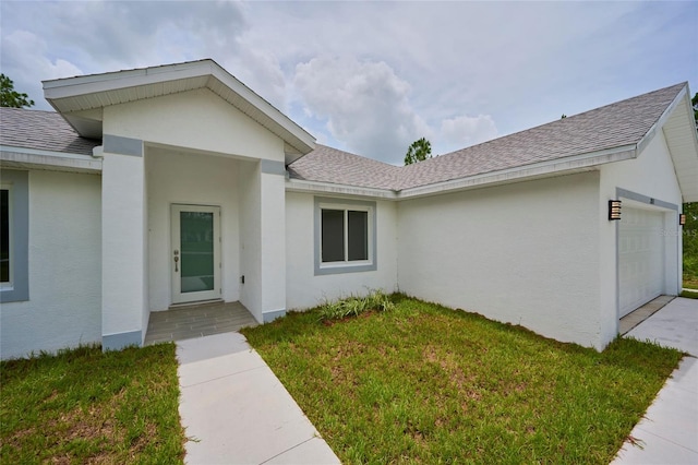 property entrance featuring a yard and a garage