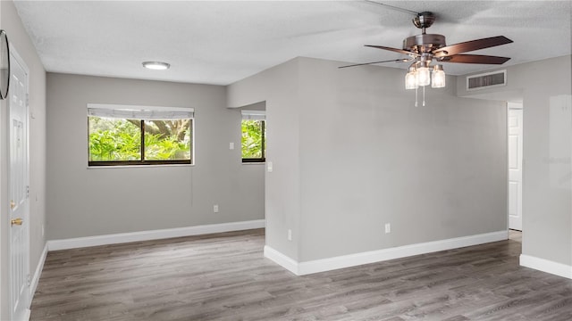 unfurnished room featuring hardwood / wood-style flooring, ceiling fan, and a textured ceiling