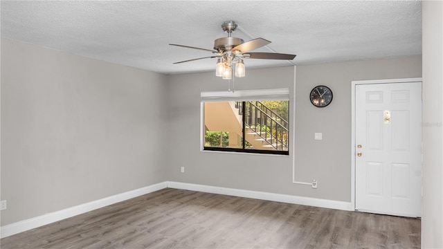 empty room featuring wood-type flooring, ceiling fan, and a textured ceiling