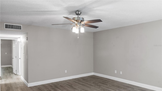 spare room featuring ceiling fan, dark wood-type flooring, and a textured ceiling