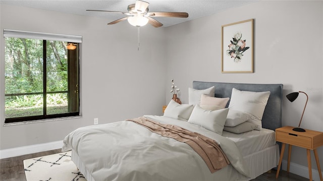 bedroom with multiple windows, ceiling fan, dark hardwood / wood-style floors, and a textured ceiling