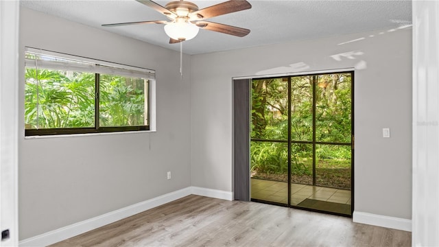 spare room featuring ceiling fan, a textured ceiling, and light wood-type flooring