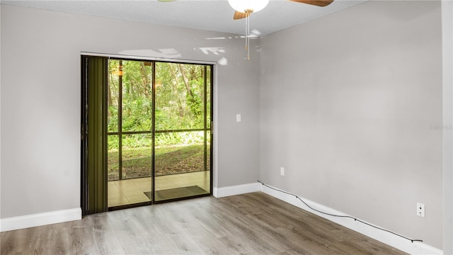 empty room featuring a textured ceiling, light hardwood / wood-style flooring, and ceiling fan