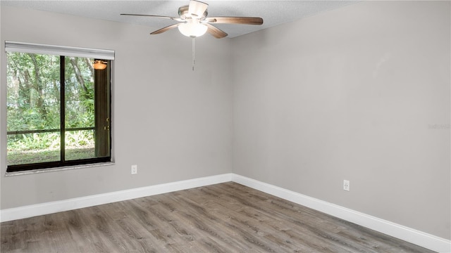 spare room featuring hardwood / wood-style flooring, ceiling fan, and a wealth of natural light