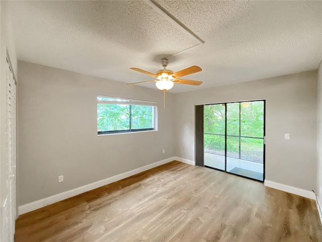 spare room with a textured ceiling, ceiling fan, and light wood-type flooring