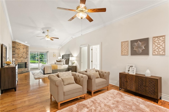 bedroom with ceiling fan, a large fireplace, wood-type flooring, and ornamental molding