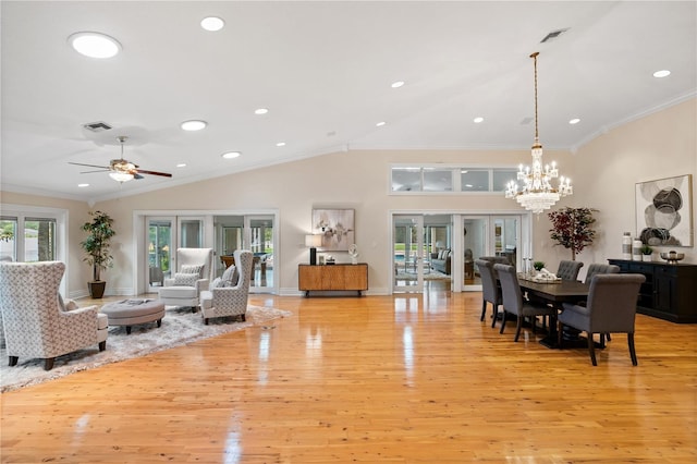 living room featuring ceiling fan with notable chandelier, lofted ceiling, light hardwood / wood-style flooring, and crown molding