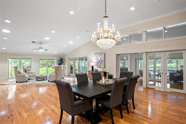 dining space with french doors, light hardwood / wood-style flooring, ceiling fan with notable chandelier, and ornamental molding