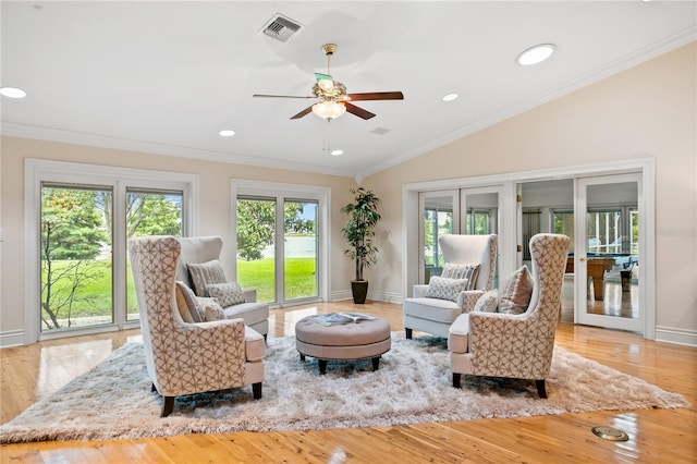 living room featuring ceiling fan, light wood-type flooring, lofted ceiling, and ornamental molding